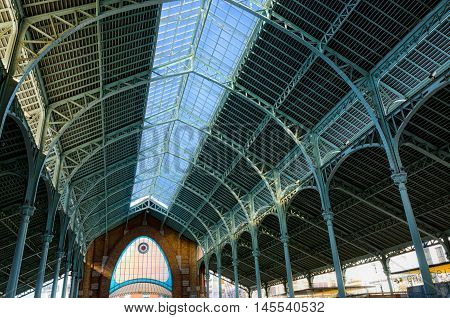 Glass roof construction of historic market Colon in Valencia, summer Spain