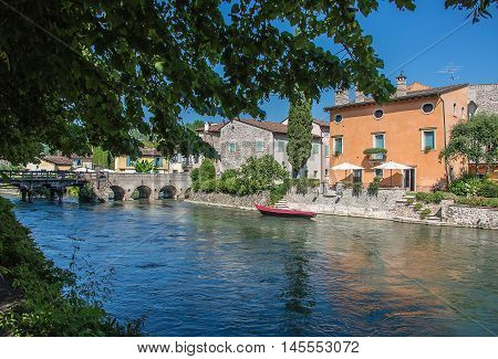 ancient buildings of a typical Italian medieval village: the river runs through the town