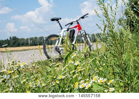 Bicycle on the roadside. Rest during the trip on a bicycle. The beautiful nature around the bicycle. Photo is aimed at promoting a healthy lifestyle.