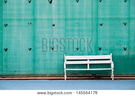 White field chair in tennis court with green plastic background.