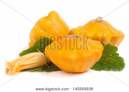 three yellow pattypan squash with leaf and flower isolated on white background.