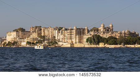 UDAIPUR INDIA - 20TH MARCH 2016: Part of the city palace in Udaipur during the day from the lake.