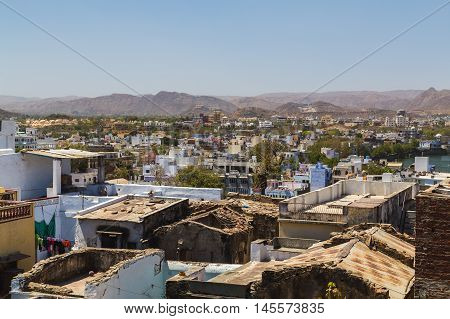 A view over rooftops in central Udaipur during the day. The Machla Hills can be seen in the distant.