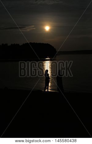 Peace tranquility - two female contour on a background of lake at sunset