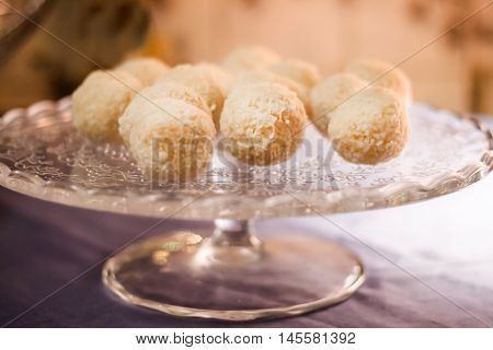 Cakes with coconut truffles in the evening light on a stand.