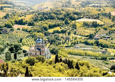 Beautiful tuscan landscape view on the green meadow with San Biagio church near Montepulciano town in Italy