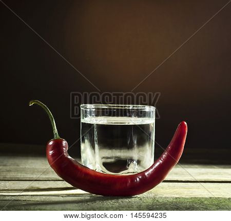 Red hot pepper on a glass of vodka
