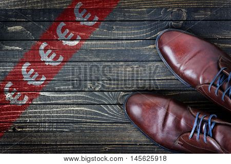 Euro sign message and business shoes on wooden floor
