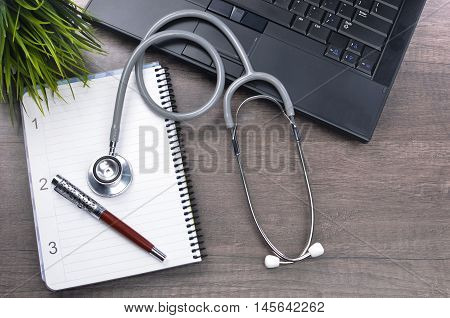 Doctor workplace with a stethscope at wooden table