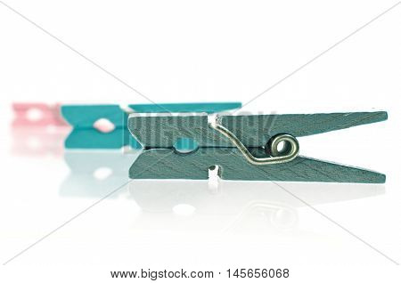 Three colorful wooden clothespins on white background