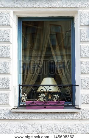 Window with a table lamp and decorative lattice with flowers