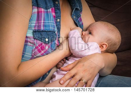 Happy mother breast feeding baby infant at home