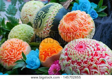 Colorful fresh carved pumpkins and melons: fruit carving or food sculpture