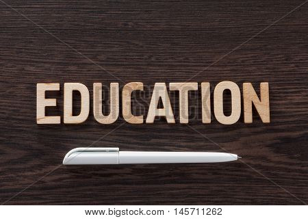 Word education written letterpress type on a dark wooden background. Back to school concept.