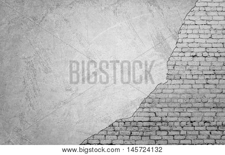 White brickwork underneath concrete wall. Textured suface. Half painted wall. Background. Cracks and roughness.