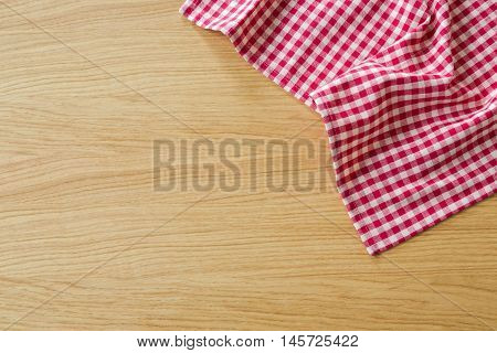 Checked tablecloth on wooden table. View from above with copy space