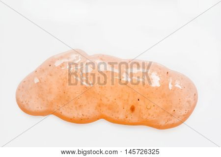 Blob of orange body scrub on white
