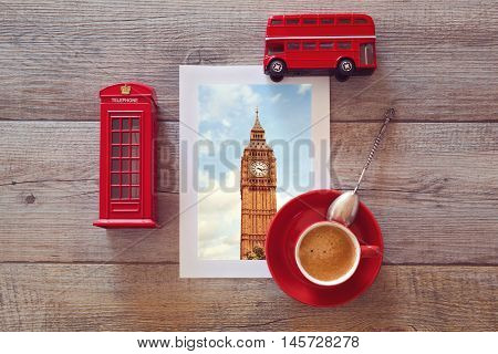 Photo of Big Ben in London on wooden table with coffee cup and suvenirs
