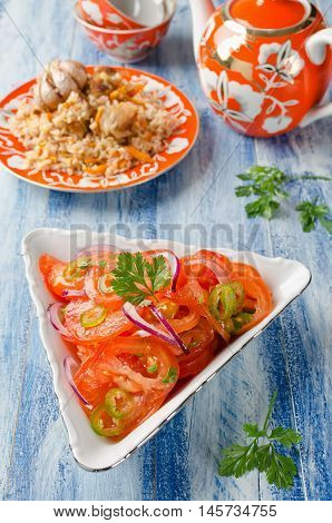Vegetable salad from tomatoes with onions and hot peppers. Traditional Uzbek salad that is served with pilaf