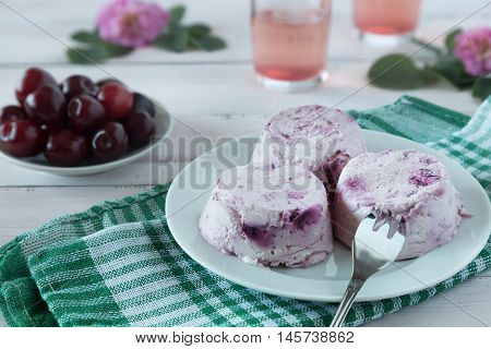 Cream and cherry dessert on a white plate