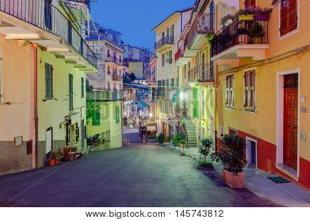 The old, narrow street in the medieval Italian village of Manarola at night. Parco Nazionale delle Cinque Terre, Liguria, Italy.