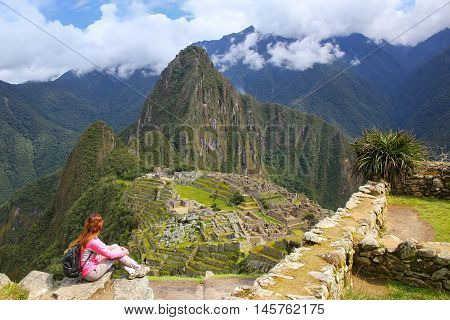 Woman enjoying the view of Machu Picchu citadel in Peru. In 2007 Machu Picchu was voted one of the New Seven Wonders of the World.