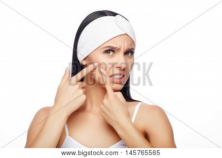 Shocked Woman Looking At Pimple On Forehead. Young Woman Squeezing her Pimple, Removing Pimple from her Face. Woman Skin Care Concept