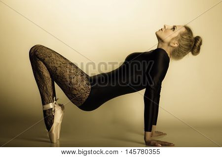 Graceful beautiful woman ballet dancer full length studio shot sepia vintage aged tone