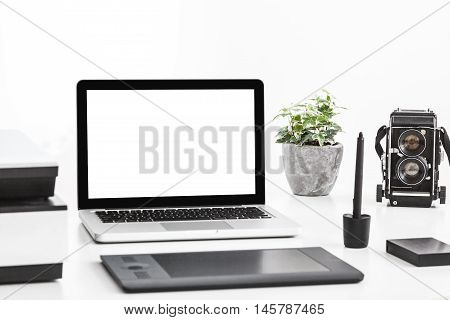 Photographer's desk with laptop, tablet and scanner for negatives. Close up.
