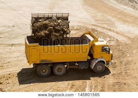 bulldozer working on the open mine loading truck
