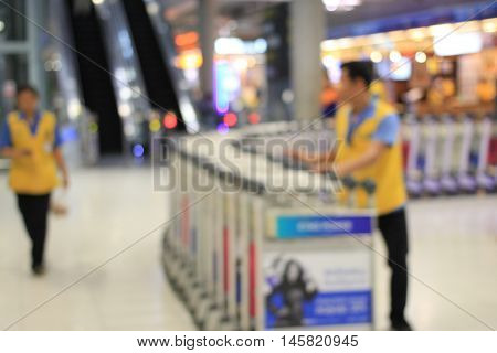 Abstract Background, Blurred Image Of A Man Working With Trolleys Luggage In Corridor Of Terminal Pa
