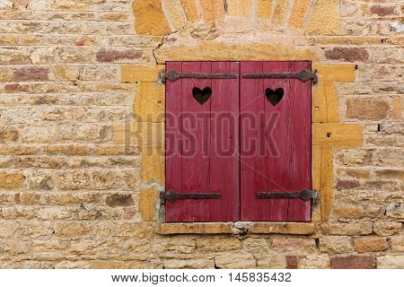 Red window shutter in the village of Oingt, Beaujolais, France
