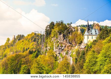 Ruins of Vranov Castle with small rock chapel, aka Pantheon, in Mala Skala on sunny summer day with blue sky and lush green trees, Bohemian Paradise, aka Cesky Raj, Czech Republic