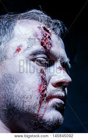 Bloody Halloween theme: crazy killer as young man with blood on dark