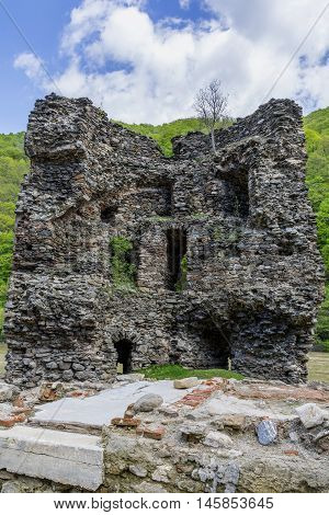 Medieval broken tower. The custom-house on Olt river in Carpathian mountains.