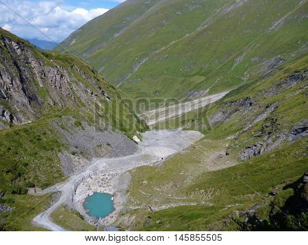 Small Emerald Lake Under A Big Dam
