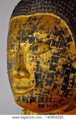 Face of Buddha image after peeling off gold leaves.