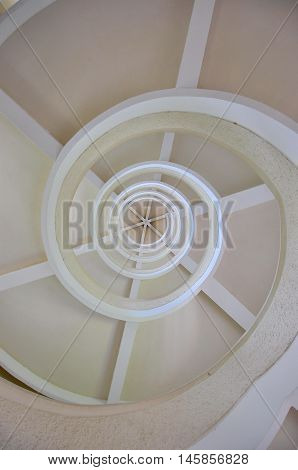 Under white spiral stairway, view from bottom up