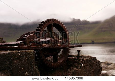 Rusted iron wheal at the coastline in the Faroe Islands