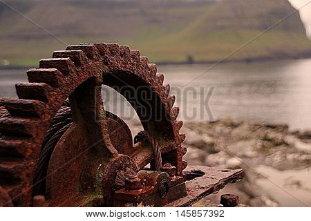Rusted iron wheal at the coastline in the Faroe Islands