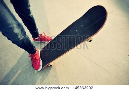 closeup of skateboarder legs skateboarding at skatepark