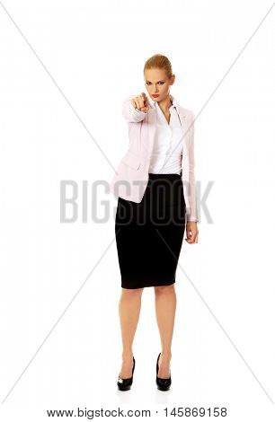 Angry business woman pointing at camera