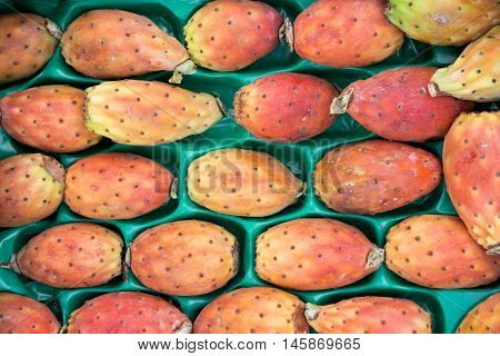 Prickly pear cactus fruits called also Opuntia ficus-indica Indian fig opuntia barbary fig tuna in a box for sale on the greek market. Fruits of prickly pear cactus on a market. Horizontal. Close.