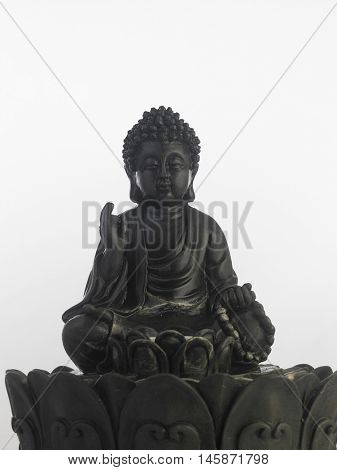 black Buddha statue in a sitting position on the white background