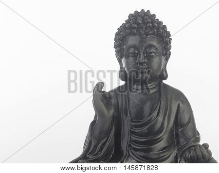 black Buddha statue in a sitting position on the white background