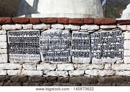 buddhist mani prayer wall on the way to Everest base camp with buddhist tibetan symbols and prayer flags Khumbu valley Sagarmatha national park Nepal