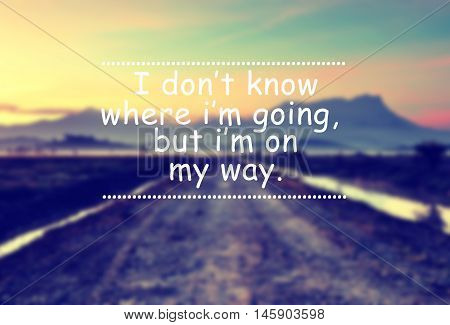 Travel inspirational quote with phrase - I don't know where i'm going but i'm on my way. Blurry mountain at sunrise background with vintage filter.