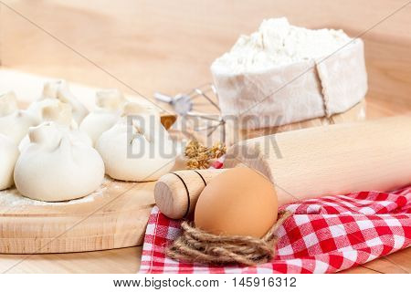 Baking ingredients for cooking manti dumplings on a wooden board.