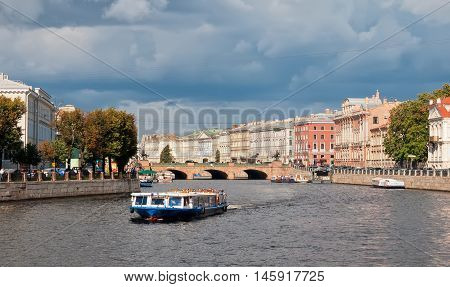 SAINT - PETERSBURG, RUSSIA - SEPTEMBER 5, 2016: People in the tourist boat sail on the Fontanka River. On the background is The Anichkov Bridge with The Horse Tamers by Peter Klodt near Nevsky Avenue