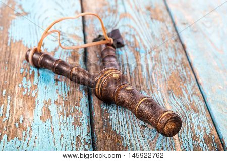 Slingshot on a painted blue wooden boards.